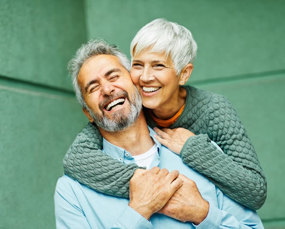Adult patient smiling after full-arch implant dentistry
